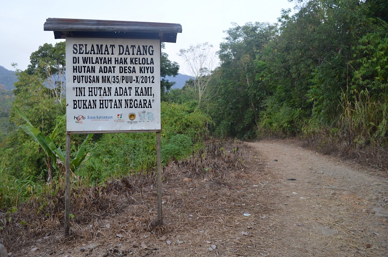 At the entrance to Kiyu Forest, a sign reminds visitors of the forest's customary ownership. (Jazak Akbar Hidayat) A sign next to a dirt road reads in Indonesian, ‘Welcome to the territory of the Kiyu customary forest under Constitutional Court Decree No. 35/PUU-X/2012. THIS IS OUR CUSTOMARY FOREST, NOT STATE FOREST.’